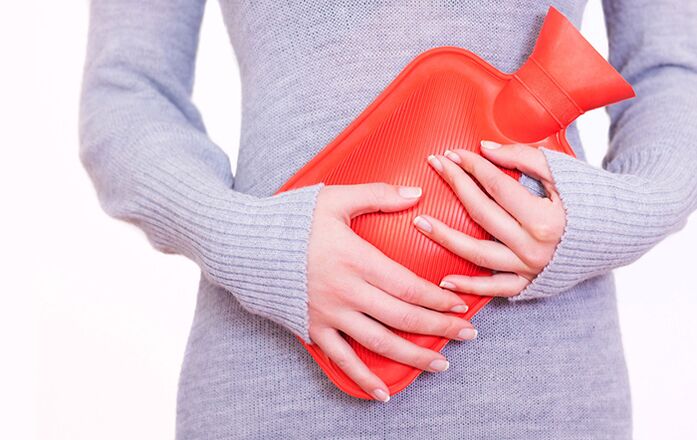 L'application d'un coussin chauffant sur le ventre aide une femme à soulager les symptômes de la cystite.